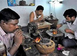 “Jeweller calculating gold Jewellery Making Charges with tools and gold ornaments.”